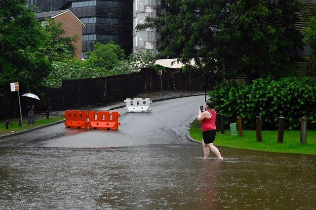 a woman walks past the swollen parramatta river as the state of new south wales experiences heavy rains in sydney australia march 20 2021 photo reuters