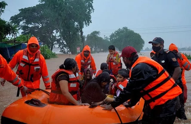 rescue workers evacuate people from a flooded area to safer places after heavy rains in kolhapur in the western state of maharashtra india july 23 2021 photo reuters rescue workers evacuate people from a flooded area to safer places after heavy rains in kolhapur in the western state of maharashtra india july 23 2021 photo reuters