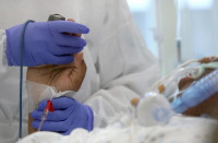 a medical worker holds the hand of a patient suffering from the coronavirus at the chirec delta hospital in brussels belgium october 23 2020 photo reuters