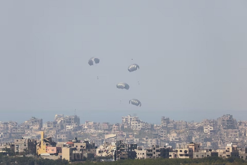 Humanitarian aid falls through the sky towards the Gaza Strip after being dropped from an aircraft, as seen from Israel's border with Gaza, in southern Israel, March 21, 2024. PHOTO: REUTERS