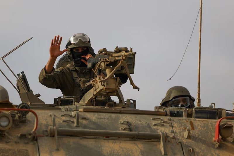 israeli military personnel drive an armoured personnel carrier apc near the israel gaza border as seen from israel april 3 2024 photo reuters