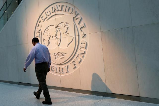 a man walks past the international monetary fund imf logo at its headquarters in washington us may 10 2018 photo reuters file
