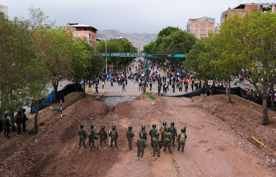 police officers stand on a street as protesters take part in a protest demanding the dissolution of the congress and to hold democratic elections rather than recognising dina boluarte as peru s president after the ouster of peruvian president pedro castillo in cuzco peru december 14 2022 reuters alejandra orosco