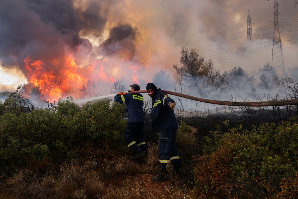 volunteer firefighters try to extinguish a wildfire at varympompi suburb north of athens greece august 3 2021 photo reuters