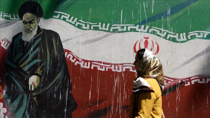 woman walks past a mural in iran photo anadolu agency