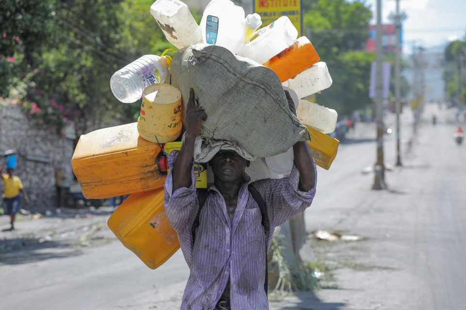 a man carries containers to fill with water amid water shortages due to daily protests against high gasoline prices and crime and to stock up for storm fiona approaching in the caribbean region in port au prince haiti september 17 2022 reuters ralph tedy erol