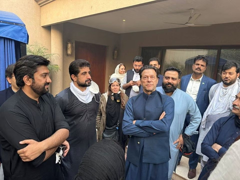 former prime minister imran khan stands with people in zaman park after security forces had fired tear gas and water cannons at hundreds of imran khan s supporters who had cordoned off his home in an effort to prevent his arrest in lahore pakistan on march 15 2023 photo reuters