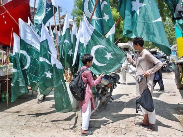 two young men select a flag at a kiosk in bahawalpur preparations for independence day celebration are in full swing across the province as both citizens and authorities are decorating their vicinities with flags lights and posters photo app