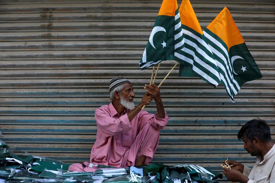 a man sells kashmir s flags and patriotic memorabilia ahead of pakistan s independence day along a market in karachi pakistan photo reuters