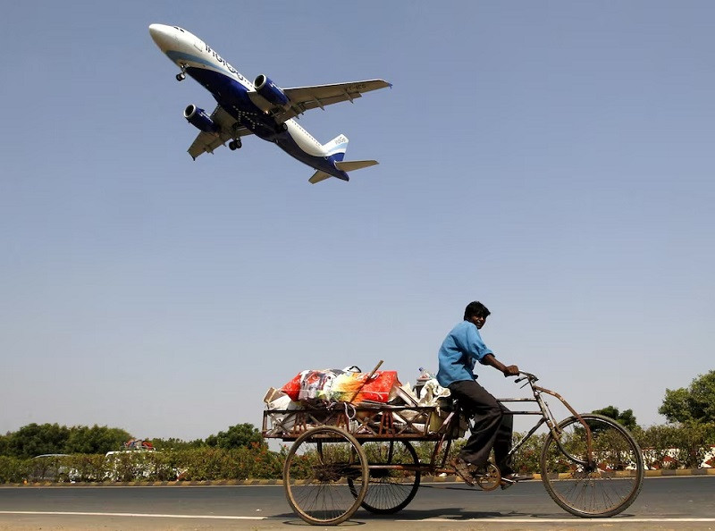 an indigo airlines aircraft prepares to land as a man paddles his cycle rickshaw in ahmedabad india october 26 2015 photo reuters