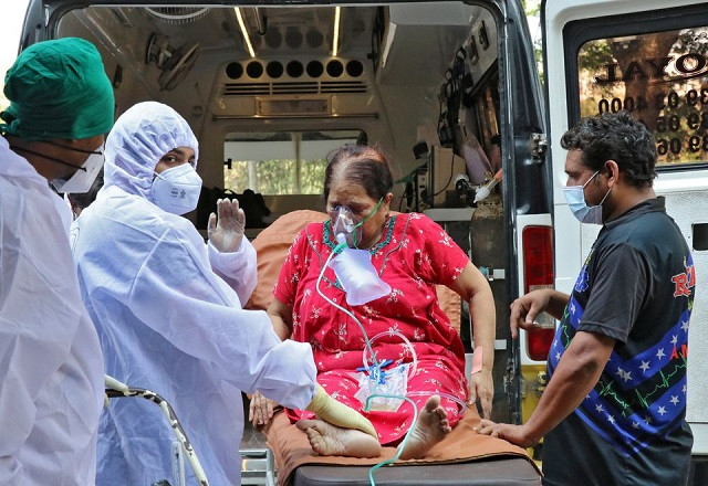 healthcare workers and relatives carry a woman from an ambulance for treatment at a covid 19 care facility amidst the spread of the coronavirus disease covid 19 in mumbai india may 4 2021 photo reuters