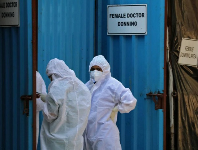 healthcare workers wearing personal protective equipment ppe stand outside a donning area at a covid 19 care facility amidst the spread of the coronavirus disease covid 19 in mumbai india may 4 2021 photo reuters