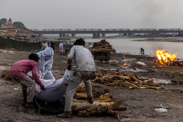 people place the body of a man who died from the coronavirus disease on a pyre before his cremation on the banks of the river ganges in india photo reuters file