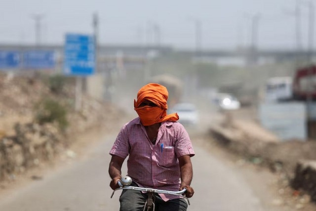 a man rides his cycle near a landfill site on a hot summer day during a heatwave in new delhi india may 27 2024 photo reuters a man rides his cycle near a landfill site on a hot summer day during a heatwave in new delhi india may 27 2024 photo reuters
