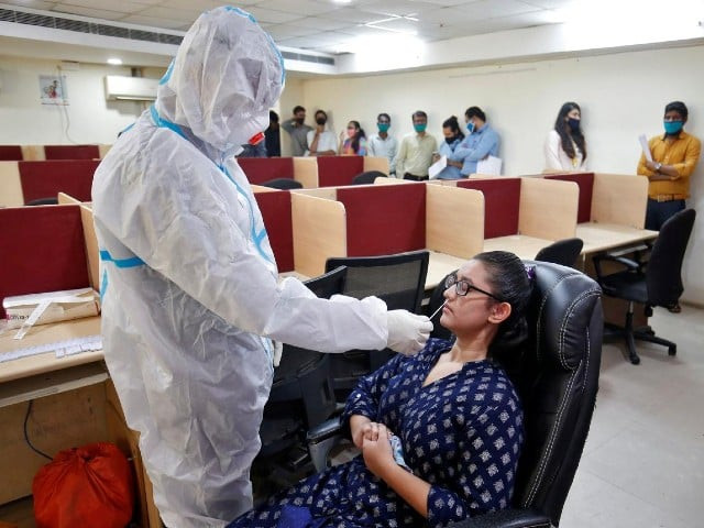 a healthcare worker wearing personal protective equipment ppe takes a swab from a woman for a rapid antigen test inside an office amidst the coronavirus disease covid 19 outbreak in ahmedabad india september 2 2020 photo reuters