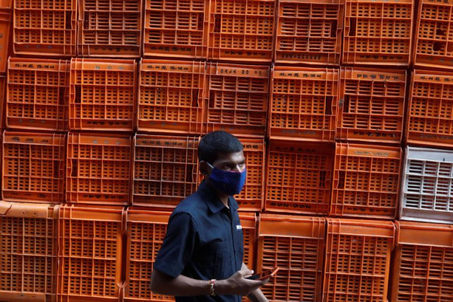 a man wearing a protective mask walks past baskets stacked at a flower market amidst the spread of the coronavirus disease covid 19 in mumbai india photo reuters file a man wearing a protective mask walks past baskets stacked at a flower market amidst the spread of the coronavirus disease covid 19 in mumbai india photo reuters file