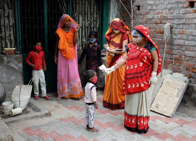 a healthcare worker checks the temperature of a child during a door to door surveillance to safeguard children amidst the spread of the coronavirus disease covid 19 at a village on the outskirts of ahmedabad india june 9 2021 photo reuters a healthcare worker checks the temperature of a child during a door to door surveillance to safeguard children amidst the spread of the coronavirus disease covid 19 at a village on the outskirts of ahmedabad india june 9 2021 photo reuters