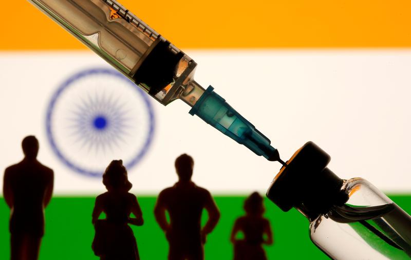 a vial syringe and small toy figures are seen in front of a displayed india flag in this illustration taken january 11 2021 photo reuters file