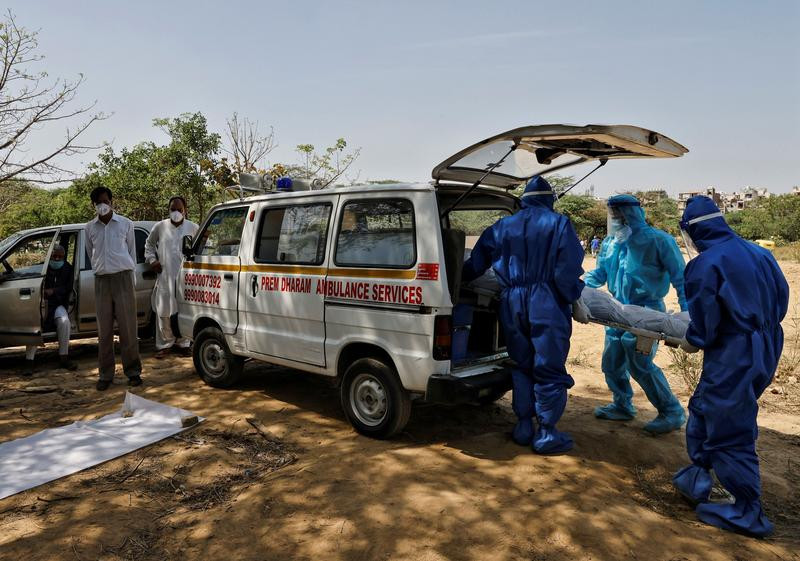 health workers carry the body of a man who died from the coronavirus disease covid 19 for burial at a graveyard in new delhi india april 9 2021 photo reuters