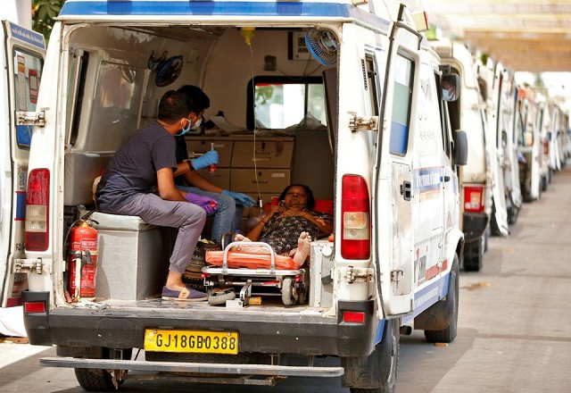 A woman with breathing problem waits inside an ambulance for her turn to enter a Covid-19 hospital for treatment, amidst the spread of the coronavirus disease (Covid-19) in Ahmedabad, India, April 28, 2021. PHOTO: REUTERS