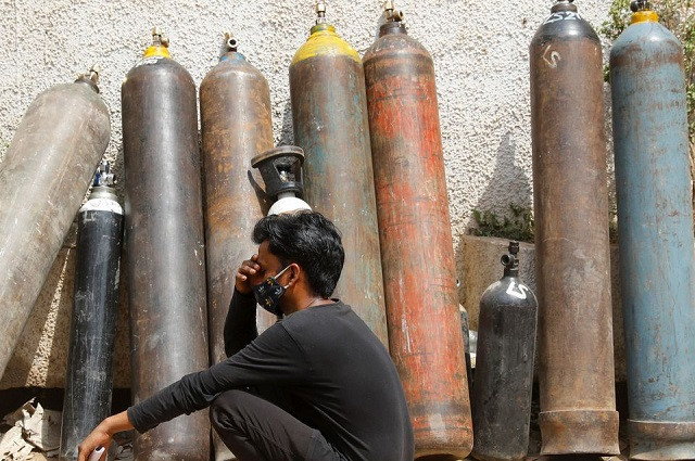 A man waits outside a factory to get his oxygen cylinder refilled, amidst the spread of the coronavirus disease (Covid-19) in New Delhi, India, April 28, 2021. PHOTO: REUTERS