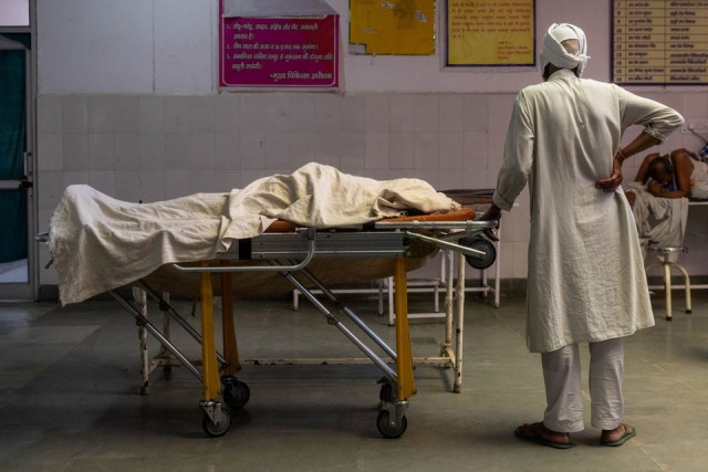 a man stands next to the body of his wife who died due to breathing difficulties inside an emergency ward of a government run hospital amidst the coronavirus disease covid 19 pandemic in bijnor uttar pradesh india may 11 2021 photos reuters a man stands next to the body of his wife who died due to breathing difficulties inside an emergency ward of a government run hospital amidst the coronavirus disease covid 19 pandemic in bijnor uttar pradesh india may 11 2021 photos reuters