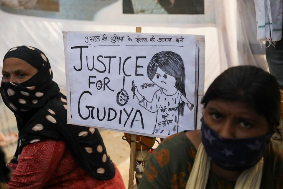 women sit next to a placard near a crematorium where people are protesting against the alleged rape and murder of a 9 year old girl in new delhi india august 5 2021 photo reuters