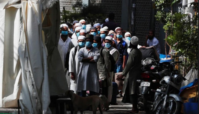 men wearing protective masks wait for a bus that will take them toa quarantine facility amid concerns about the sprea of coronavirus disease covid 19 in nizamuddin area od new delhi india march 31 2020 photo reuters men wearing protective masks wait for a bus that will take them toa quarantine facility amid concerns about the sprea of coronavirus disease covid 19 in nizamuddin area od new delhi india march 31 2020 photo reuters