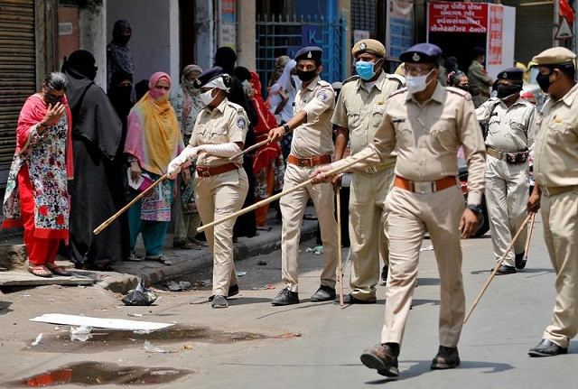 police officers advise women to maintain distance as they wait to collect grocery during an extended nationwide lockdown to slow the spreading of coronavirus disease covid 19 in ahmedabad april 16 2020 photo reuters