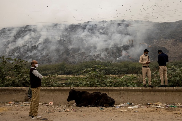 members of delhi government anti pollution squad report the status of the fire as smoke billows from burning garbage at the ghazipur landfill site in new delhi india photo reuters file