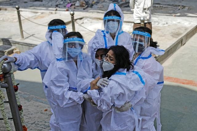 relatives wearing personal protective equipment ppe mourn a man who died from the coronavirus disease covid 19 at a crematorium in new delhi india april 21 2021 photo reuters