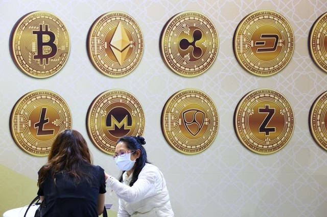 customers talk against a backboard with signs of cryptocurrency during 2020 taipei international finance expo in taipei taiwan november 27 2020 photo reuters