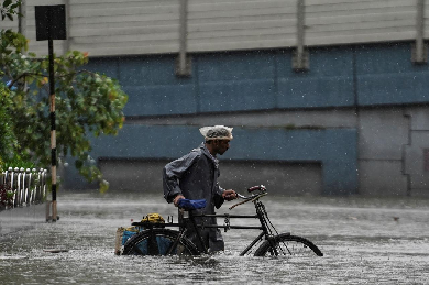 a man pushes his bicycle through a flooded road during heavy rains in mumbai india august 4 2020 photo reuters