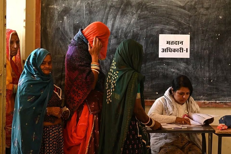 Women wait in a queue to cast their votes at a polling station during Rajasthan state assembly election in Ajmer, India, November 25, 2023. PHOTO: REUTERS
