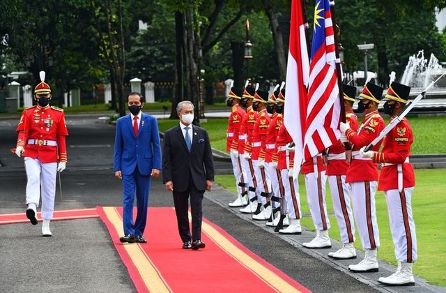 malaysian prime minister muhyiddin yassin and indonesian president joko widodo walk during a welcoming ceremony at the presidential palace in jakarta indonesia february 5 2021 photo reuters