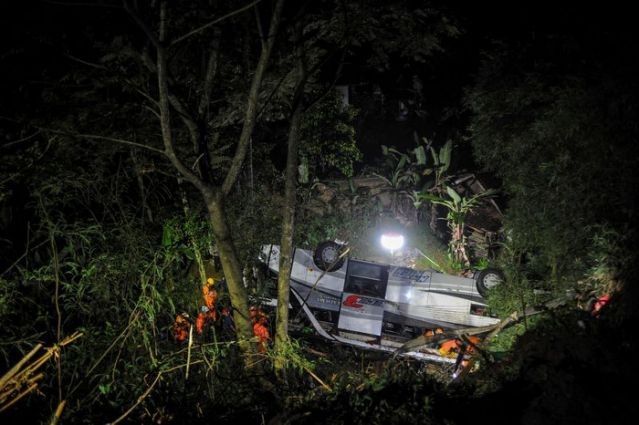 Rescue personnel work at the crash site after a bus fell into a ravine in Sumedang, West Java Province, Indonesia March 10, 2021, in this photo taken by Antara Foto. Picture taken March 10, 2021. PHOTO: REUTERS