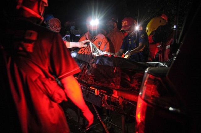 Rescue personnel transport a body bag containing a victim of a bus that fell into a ravine in Sumedang, West Java Province, Indonesia March 11, 2021, in this photo taken by Antara Foto. PHOTO: REUTERS