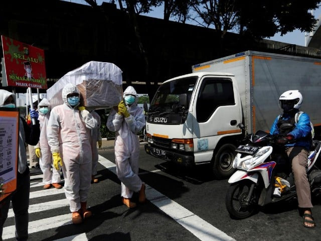 government workers wearing protective suits carry a mock up of a coffin of a coronavirus disease covid 19 victim as others carry signs displaying information about the number of covid 19 cases on a main road to warn people about the dangers of the disease as the outbreak continues in jakarta indonesia august 28 2020 photo reuters file government workers wearing protective suits carry a mock up of a coffin of a coronavirus disease covid 19 victim as others carry signs displaying information about the number of covid 19 cases on a main road to warn people about the dangers of the disease as the outbreak continues in jakarta indonesia august 28 2020 photo reuters file