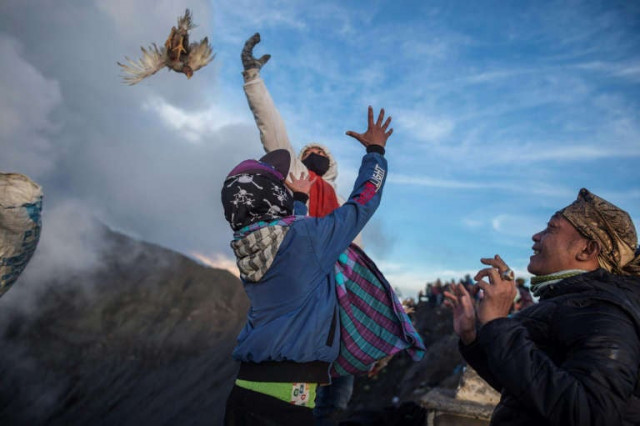 worshippers throw their offerings into the volcano of mount bromo as a sacrifice to the gods photos afp worshippers throw their offerings into the volcano of mount bromo as a sacrifice to the gods photos afp