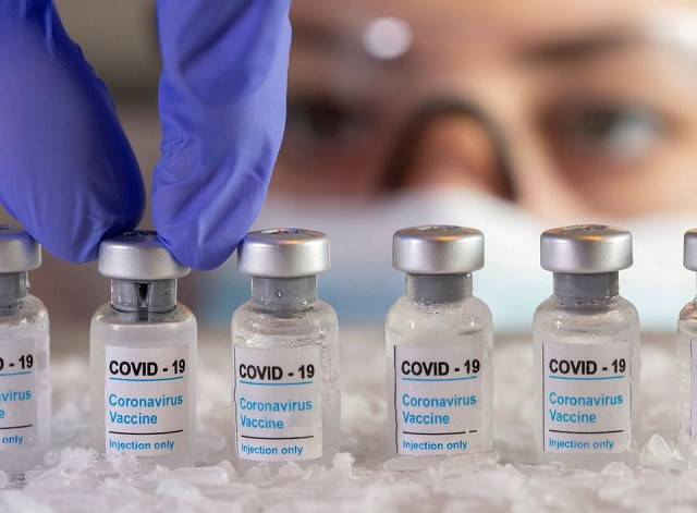 woman holds vials labelled covid 19 coronavirus vaccine over dry ice in this illustration taken december 5 2020 photo reuters