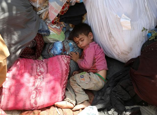 An internally displaced child from northern provinces, who fled from his home due the fighting between Taliban and Afghan security forces, sleeps in a public park that they use as shelter in Kabul, Afghanistan, August 10, 2021. PHOTO: REUTERS