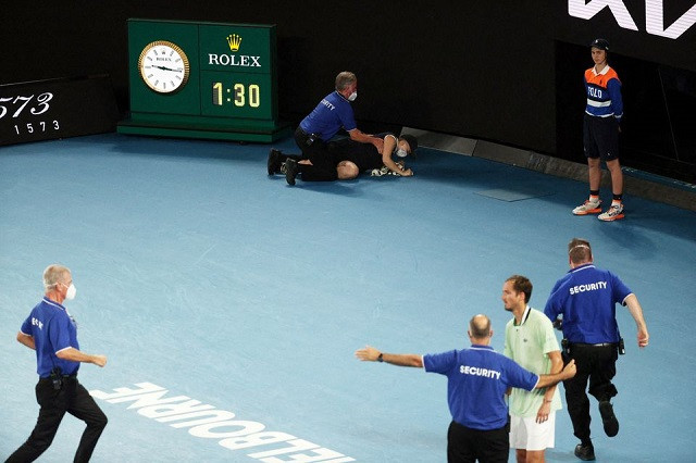 a protestor is detained by security after jumping on to the court during the final in melbourne australia on jan 30 2022 photo reuters