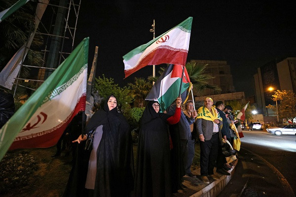Demonstrators wave Iran's flag and Palestinian flags as they gather at Palestine Square in Tehran. PHOTO: AFP