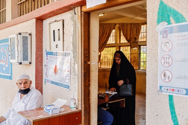 a woman scans her finger to verify her identity before voting at a polling station during the parliamentary election in kerbala iraq october 10 2021 photo reuters