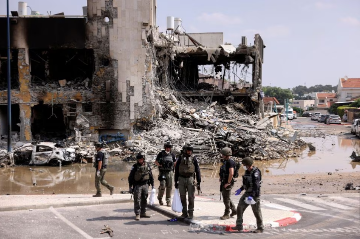 Israeli security gather near a rifle at the site of a battle with Hamas fighters, in Sderot, southern Israel. PHOTO: Reuters