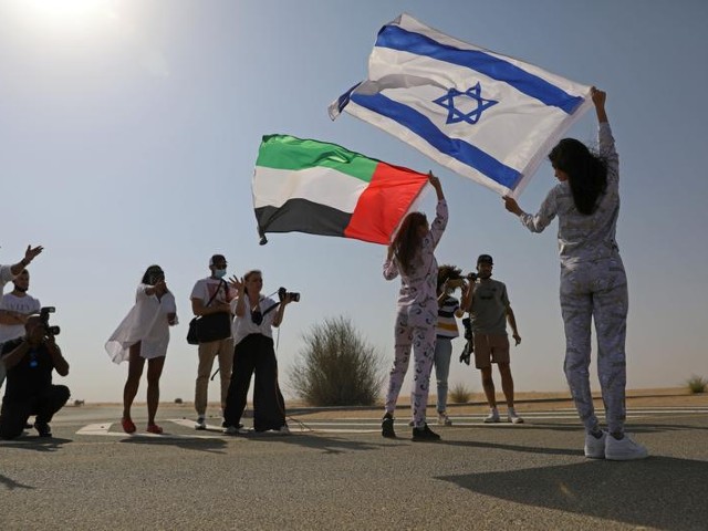 israeli model may tager holding an israeli flag poses with dubai resident model anastasia holding an emirati flag during a photoshoot for fix s princess collection in dubai united arab emirates september 8 2020 photo reuters file