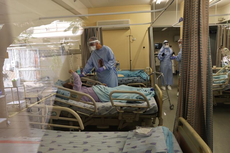 doctor guy choshen director of the covid 19 ward in ichilov hospital speaks to a patient inside the war in tel aviv israel january 10 2021 photo reuters