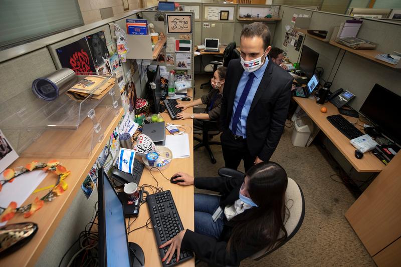 yonatan gonen who heads the arabic language social media unit within the israeli foreign ministry and lorena khateeb a team member of the unit work at their office in jerusalem december 1 2020 reuters file