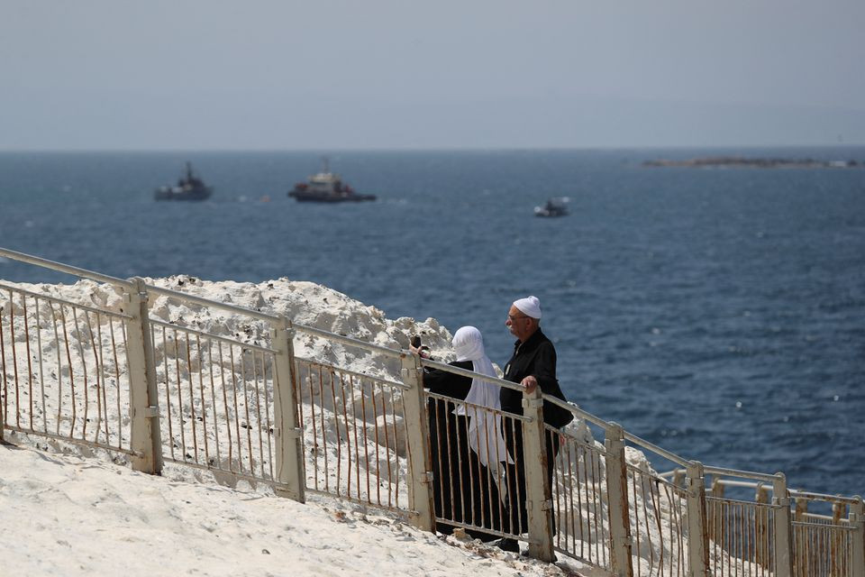 people walk as israeli navy boats are seen in the mediterranean sea as seen from rosh hanikra close to the lebanese border northern israel may 4 2021 photo reuters