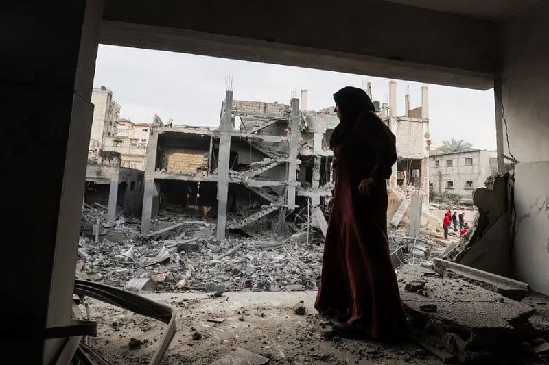 a palestinian woman stands at the site of israeli strikes on houses in khan younis in the southern gaza strip photo reuters